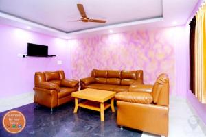 uma sala de estar com mobiliário de couro e uma televisão em Hotel Krishna Residency Puri Excellent Stay em Puri