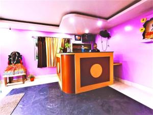 um quarto com uma parede rosa com uma mesa em Hotel Krishna Residency Puri Excellent Stay em Puri