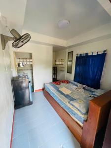 a bedroom with a bed with a blue curtain at Anong Villa in Amphoe Koksamui