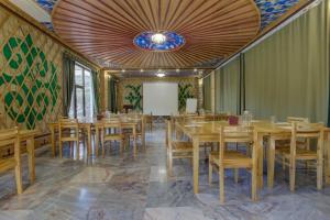 a dining room with wooden tables and chairs and a whiteboard at Mountain View Hot Spring Resort in Alamedin