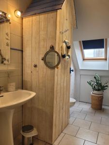 a bathroom with a wooden door and a sink at La petite parenthèse in Muides-sur-Loire