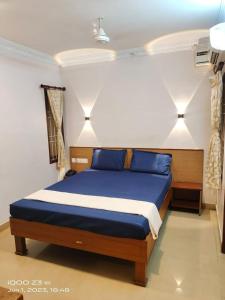 a bedroom with a bed with blue pillows at Nest Inn in Puducherry