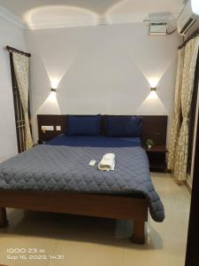 a bedroom with a blue bed with a hat on it at Nest Inn in Puducherry