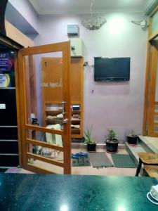 una habitación con puerta y TV y algunas plantas en Nest Inn, en Pondicherry