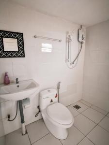 bagno bianco con servizi igienici e lavandino di Semi detached At Tabuan Jaya,13BR By Natol Homestay-London a Kuching