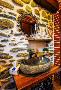 y baño con lavabo de piedra en una pared de piedra. en Casa de Piatra en Porumbacu de Sus