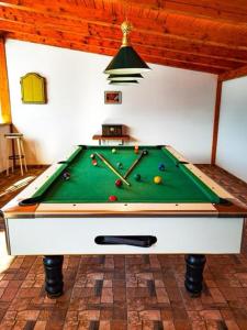 una mesa de billar con pelotas en una habitación en Casa de Piatra, en Porumbacu de Sus
