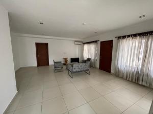 uma sala de estar com um sofá e cadeiras em Ultramodern 2 bedroom space Available em Accra