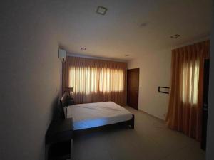 a bedroom with a bed and a window with curtains at Ultramodern 2 bedroom space Available in Accra