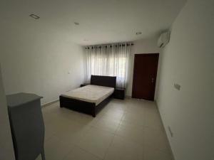 a small bedroom with a bed and a window at Ultramodern 2 bedroom space Available in Accra