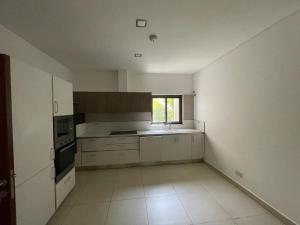 a large kitchen with white cabinets and a window at Ultramodern 2 bedroom space Available in Accra