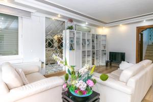ein Wohnzimmer mit 2 weißen Sofas und einem TV in der Unterkunft Villa MO DAİLY WEEKLY rentals İçmeler in Marmaris