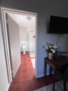 a hallway with a room with a toilet and a table at Aan d'Oewer in Citrusdal