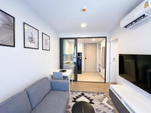 a living room with a couch and a table at Квартира с видом на сад Laguna 1313 от IBGProperty in Phuket Town