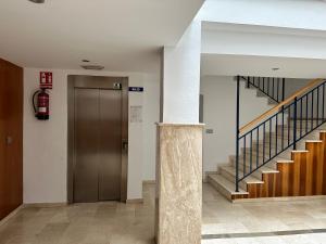 a hallway with a elevator and stairs in a building at Apartamento Trópico in La Herradura