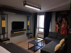 a living room with a couch and a tv at BUTİK 24 SUİTES in Ankara