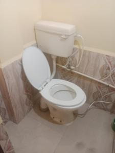 W pokoju znajduje się łazienka z białą toaletą. w obiekcie Aanand Bhwan dharmshala ayodhya w mieście Ayodhya