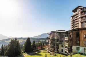 an apartment building on a hill with mountains in the background at Résidence Pierre & Vacances Premium L'Amara in Avoriaz