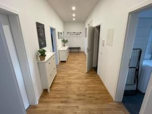 a hallway with white walls and a wooden floor at #attraktive Altbauwohnung im Leipziger Zentrum 1 OG links in Leipzig +2 photos