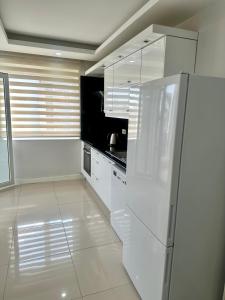 a kitchen with white cabinets and a refrigerator at confort residance in Antalya
