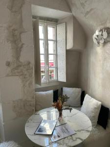 a white table with a vase of flowers on it at Le Cocon - 3 étoiles in Annecy