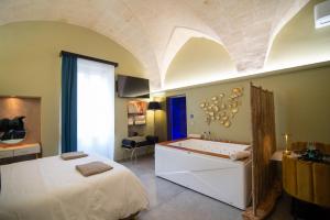 Un dormitorio con una cama y una bañera en una habitación. en Siramà Suite Deluxe, en Oria 46 fotos más