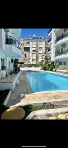 a swimming pool in front of some apartment buildings at confort residance in Antalya