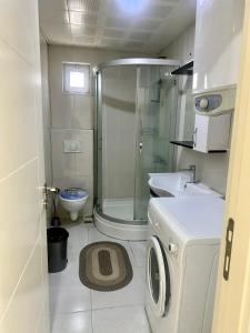 a small bathroom with a shower and a washing machine at confort residance in Antalya