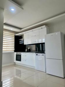a kitchen with white appliances and a white refrigerator at confort residance in Antalya