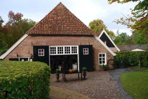 a large brick house with a large window at Erve Niehof in Diepenheim