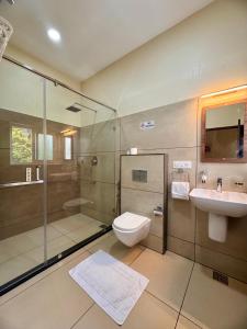 un bagno con doccia, WC e lavandino di Flower Valley Plantation Homestay a Munnar