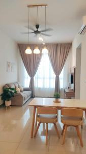 een woonkamer met een tafel en een bank bij Amber Cove Malacca City View in Melaka
