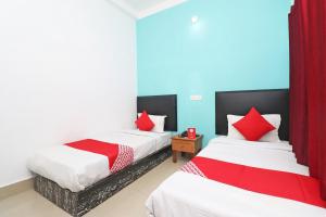 2 Betten in einem Zimmer mit roten Vorhängen in der Unterkunft OYO Flagship Fun Friday Guesthouse in Bodh Gaya