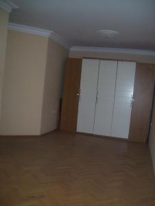 an empty room with white cabinets and wooden floors at Beylikdüzü EmekEvler Sitesinde Dublex in Beylikduzu