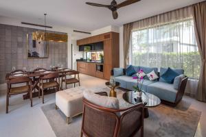 a living room with a couch and a dining room at Wyndham Hoi An Royal Beachfront Resort & Villas in Hoi An
