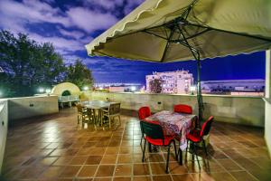 a patio with a table and chairs and an umbrella at Old City Tower Inn in Baku