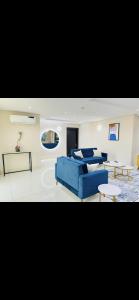 a living room with a blue couch and a table at A Luxury furnished apartment located in the hub of Ikoyi Lagos in Lagos