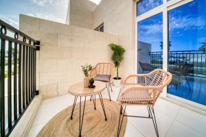 einen Balkon mit 2 Stühlen und einem Tisch in der Unterkunft Autumn Serenity Manor: Luxury 3 Bedroom Townhouse in Dubai