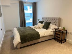 a bedroom with a large bed with a window at Mulberry House in Stevenage