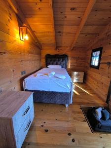 ein Schlafzimmer mit einem Bett in einer Holzhütte in der Unterkunft Paşa Bungalov HOTEL in Marmaris