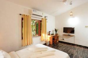 sypialnia z łóżkiem, oknem i biurkiem w obiekcie Casa Verde · Luxurious 3BHK Villa in Goa Velha w mieście Goa