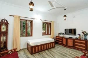 duży pokój z łóżkiem i telewizorem w obiekcie Casa Verde · Luxurious 3BHK Villa in Goa Velha w mieście Goa