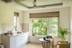 een keuken met een tafel en een groot raam bij Luxurious Apartment with a Pool near Candolim 11 in Goa