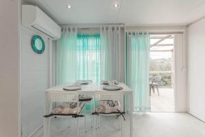 a white dining room with a table and two chairs at Mobilhome au vert in Roquebrune-sur-Argens