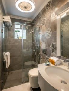 een badkamer met een douche, een toilet en een wastafel bij Luxurious Apartment with a Pool near Candolim 11 in Goa