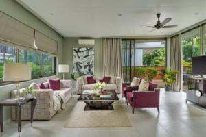 a living room with couches and purple chairs at sohonos · Luxurious 3bhk villa in Candolim in Goa