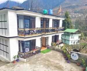 a white house with balconies and a green roof at Wonder Hill Inn in Lachung