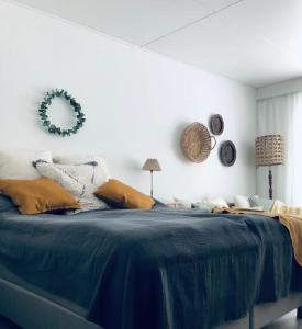 a bedroom with a bed with a blue comforter at Hangon helmi pariskunnalle tai yksin matkustavalle in Hanko
