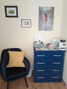 uma cómoda azul e uma cadeira num quarto em Salthill Stay B&B em Galway