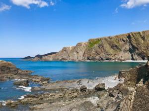 a view of a beach with rocks and the ocean at Montgomery Barn in Bideford